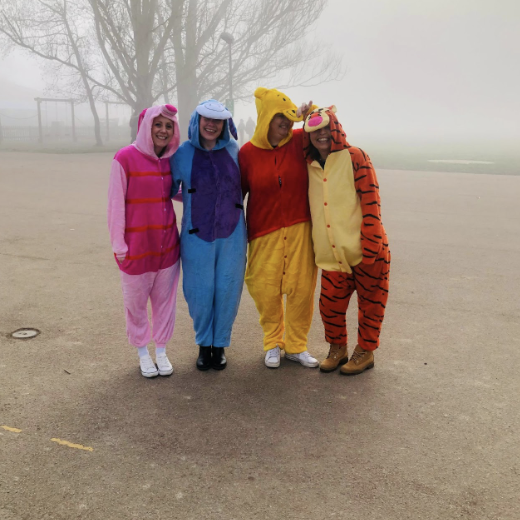 Teachers in Winnie the Pooh onesies, smiling